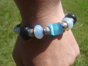 Armband av svart läder med en blå Cateye-pärla