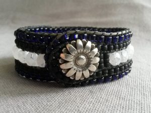 Brett fem raders handsytt läderarmband med blomknapp