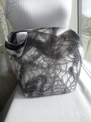 Silver och koksgrå handväska med pärlspindelväv