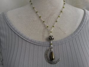 Halsband med snirklig måne pendel glaspärlor i kedjan