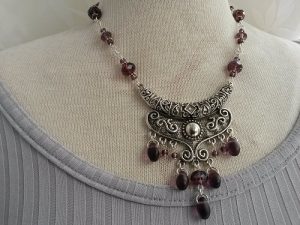 Orientalisk inspirerat snirkligt unikt lila halsband