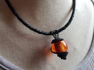 Läderhalsband svart trådslöjd hänge orange ormskinns utseende
